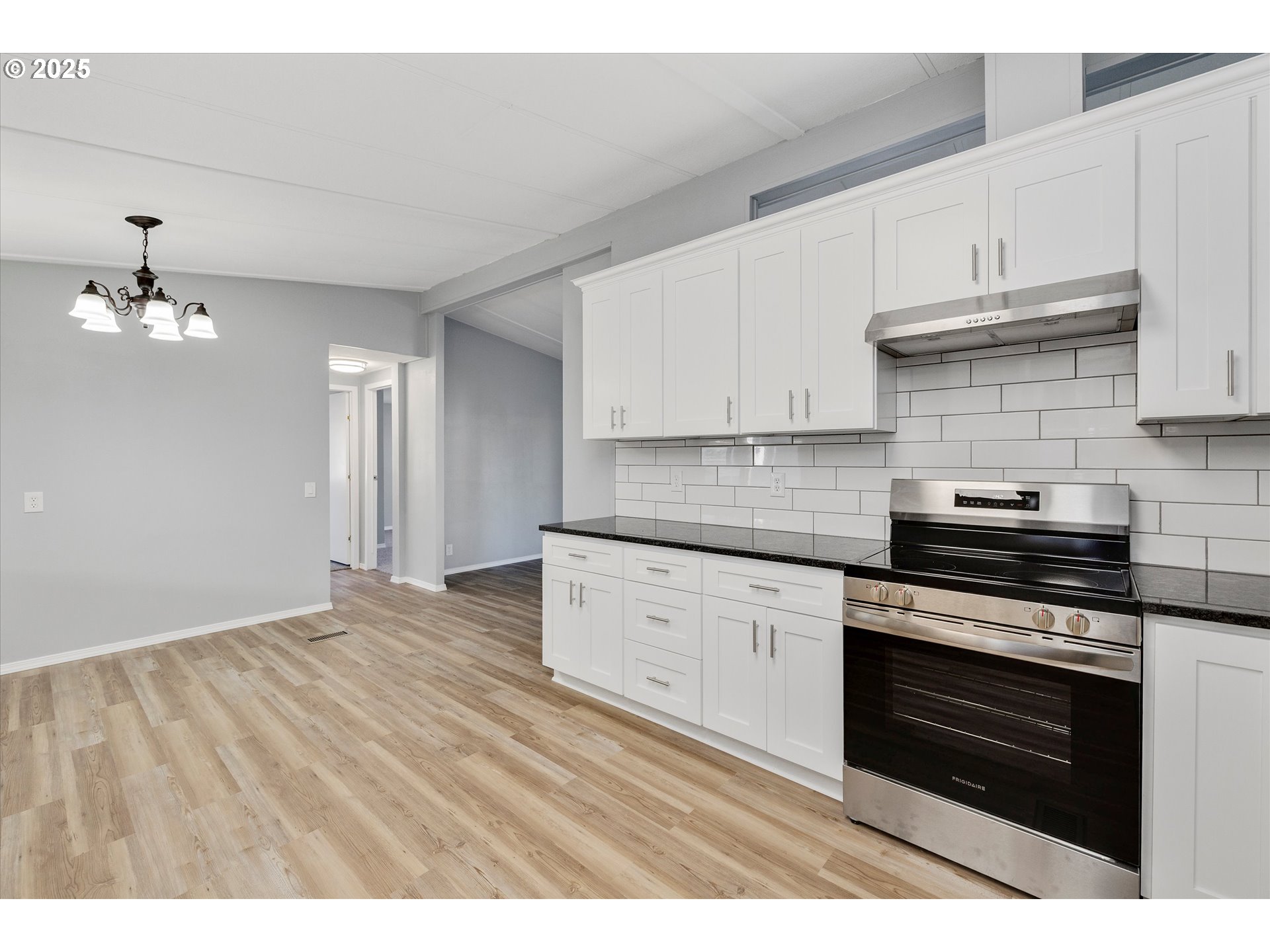 835 Southeast 1st Avenue, Unit 17 Canby, OR 97013 - Photo 14 of 33 a kitchen with granite countertop a stove cabinets and wooden floor