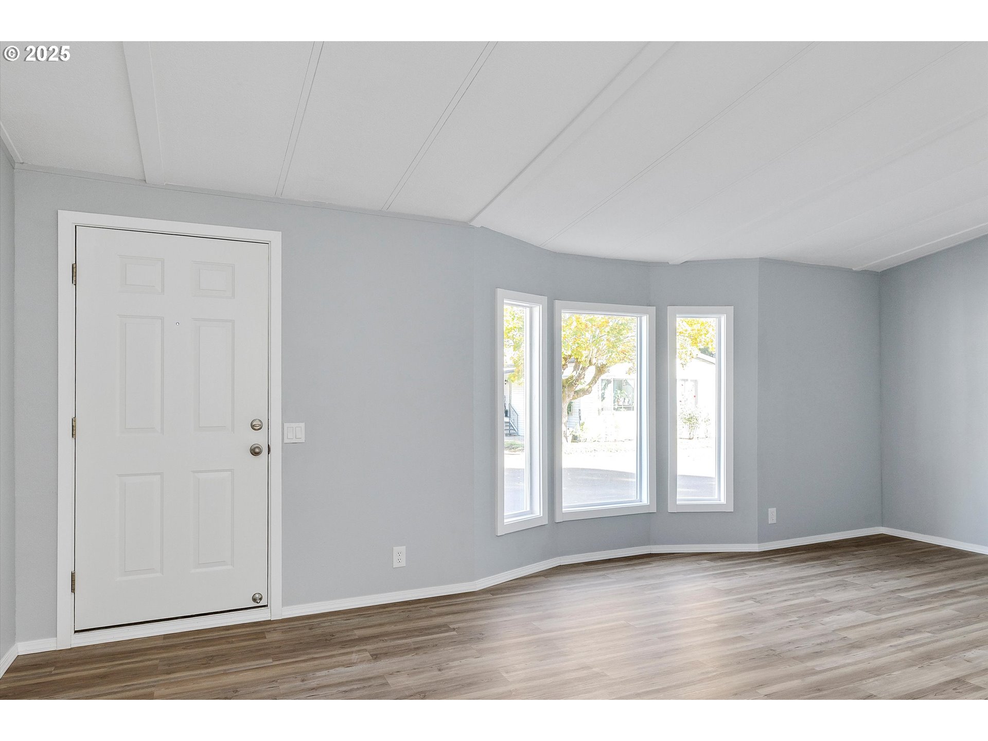 835 Southeast 1st Avenue, Unit 17 Canby, OR 97013 - Photo 5 of 33 a view of an empty room with wooden floor and a window
