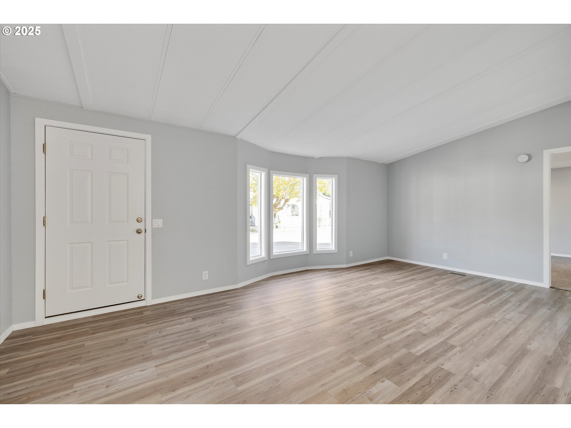 835 Southeast 1st Avenue, Unit 17 Canby, OR 97013 - Photo 6 of 33 a view of an empty room with wooden floor and a window