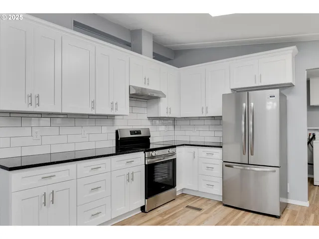a kitchen with white cabinets and white appliances