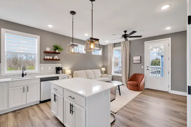 a open kitchen with stainless steel appliances granite countertop a sink dishwasher a stove and a refrigerator with wooden floor