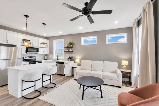 a living room with furniture and kitchen view