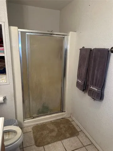 a bathroom with a toilet and a shower
