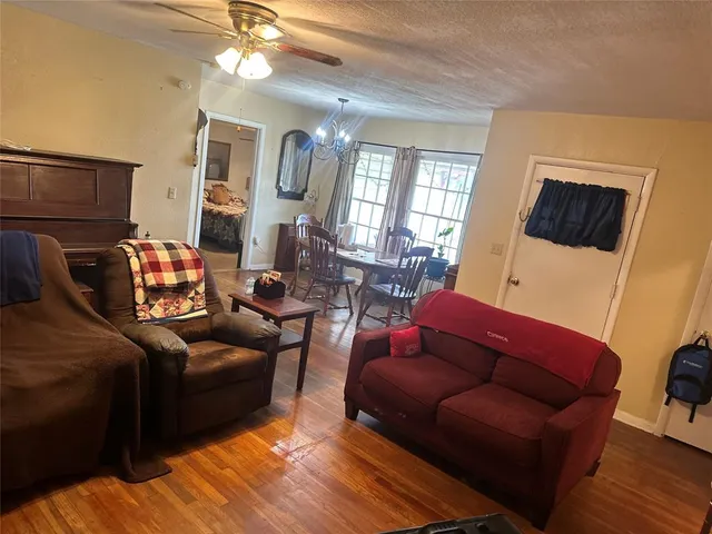 a living room with furniture a flat screen tv and wooden floor