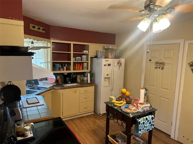 a kitchen with a refrigerator and a stove top oven