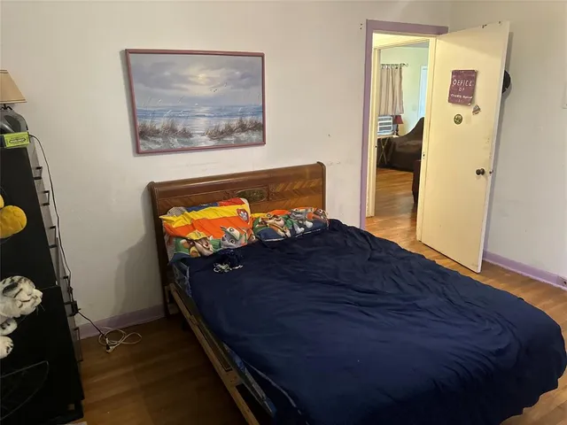 a bedroom with a bed and wooden floor