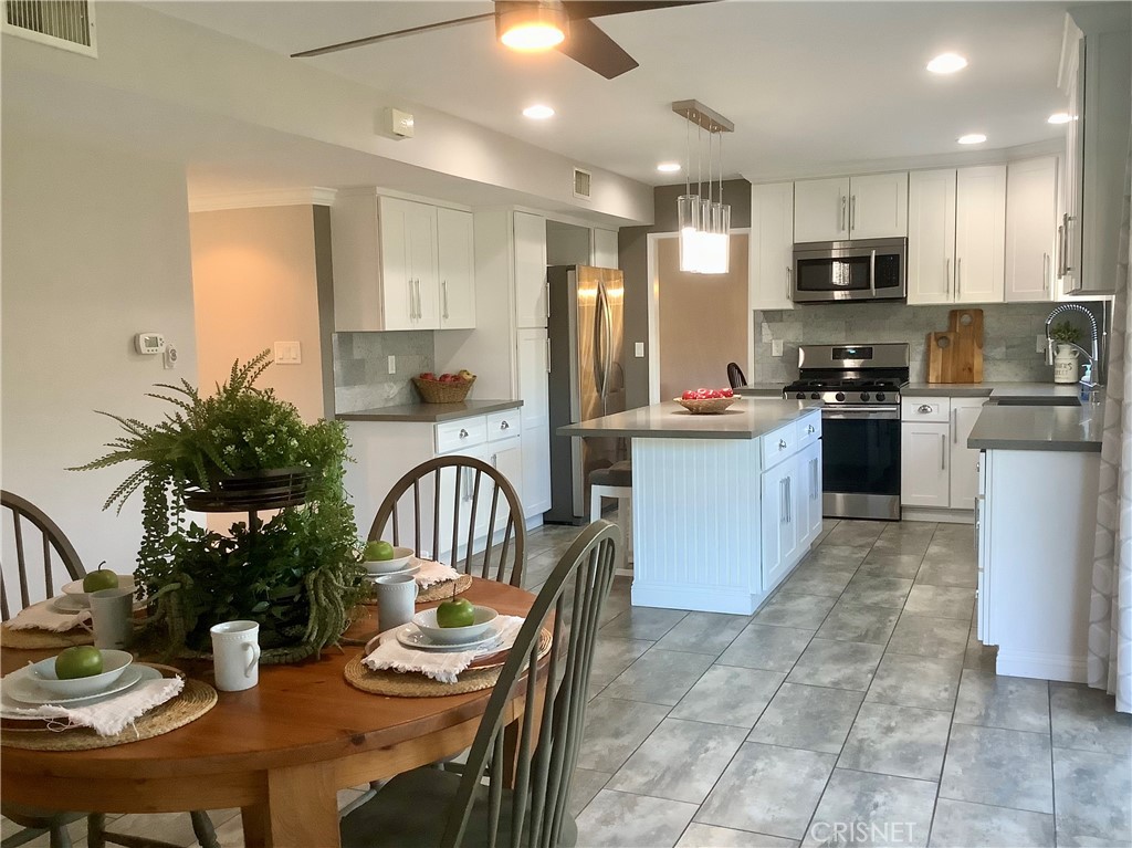 2163 Cheam Avenue Simi Valley, CA 93063 - Photo 5 of 43 a kitchen with sink a refrigerator and chairs