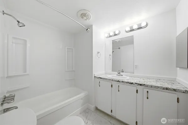 a bathroom with a granite countertop sink and a mirror
