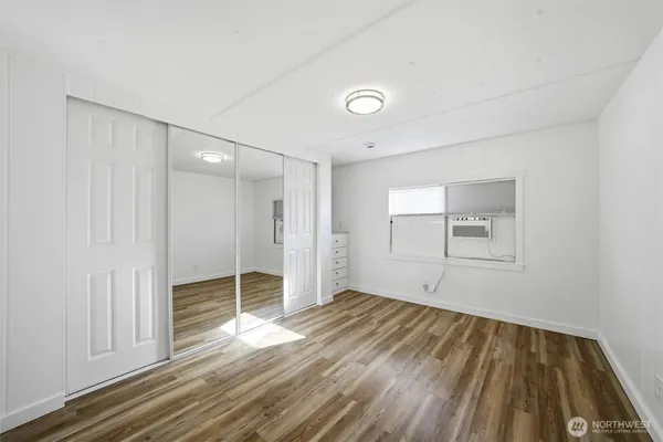 a view of empty room with wooden floor