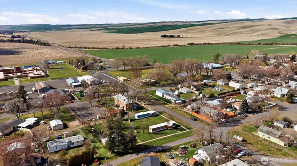 an aerial view of ocean and residential houses with outdoor space