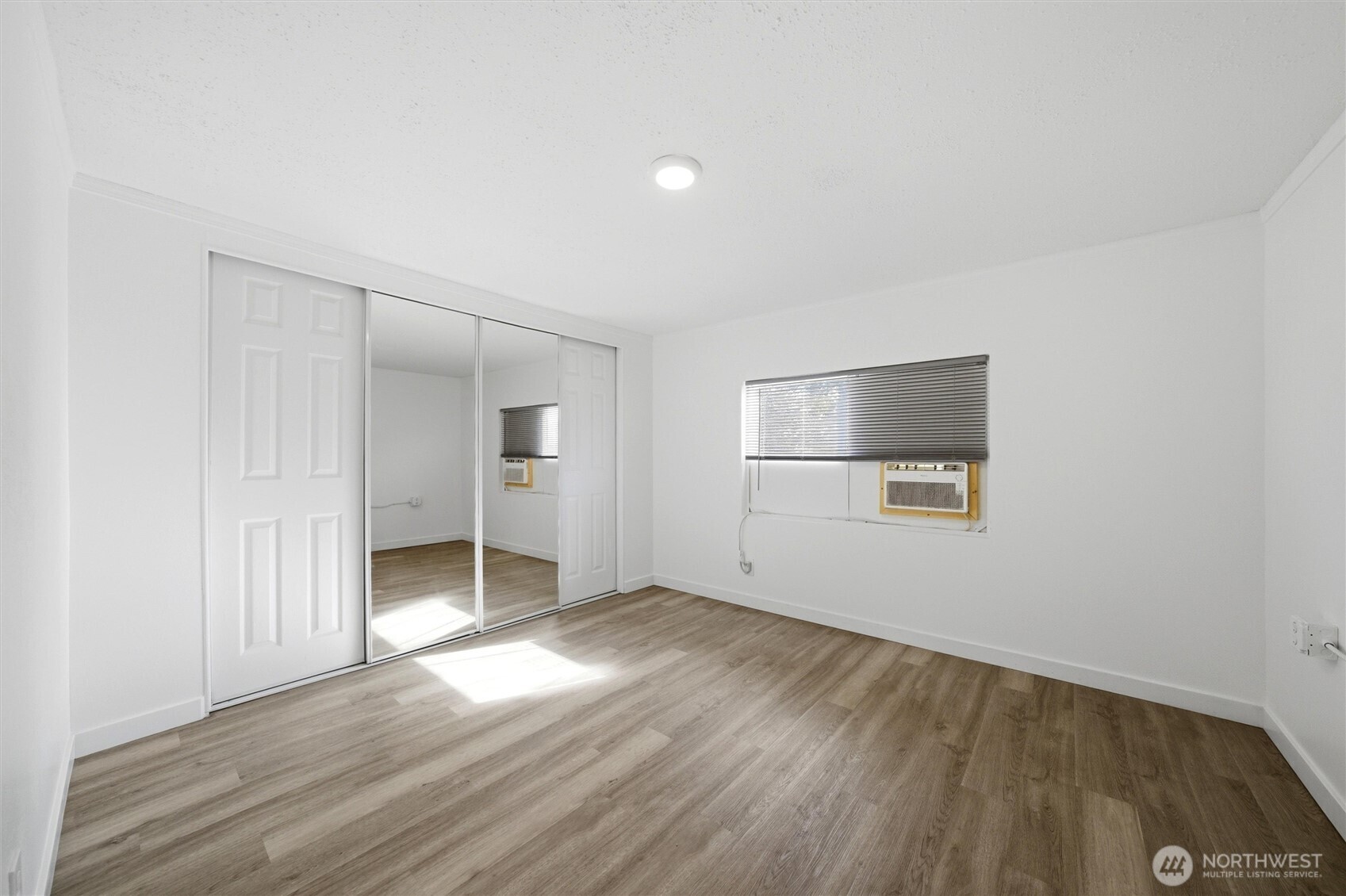 200 West 1st Street Prescott, WA 99348 - Photo 7 of 22 an empty room with wooden floor and windows
