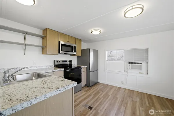 a kitchen with granite countertop a sink stove and refrigerator