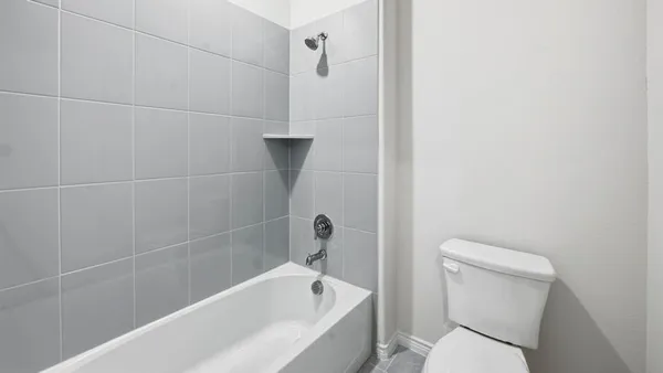 a white toilet sitting next to a bath tub