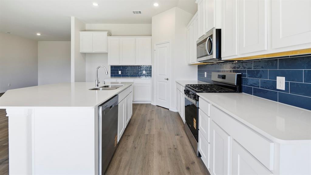 2104 Eugene Street Anna, TX 75409 - Photo 22 of 37 a kitchen with a sink a stove and cabinets