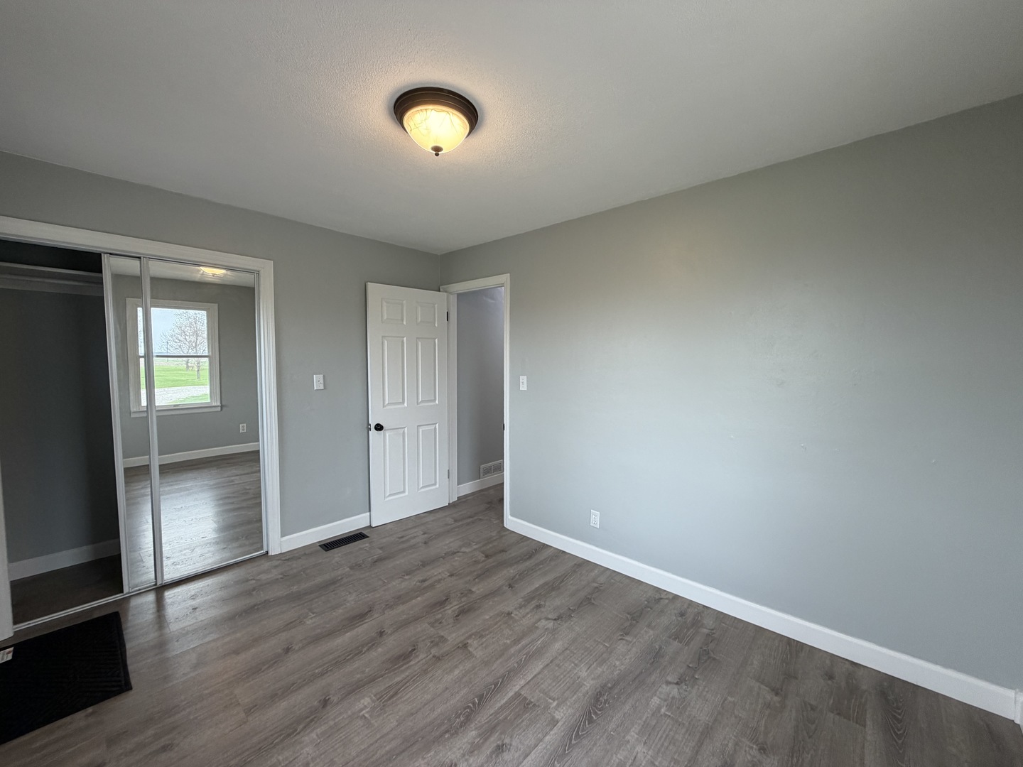 15266 LeRoy Road Farmer City, IL 61842 - Photo 14 of 36 an empty room with wooden floor and windows