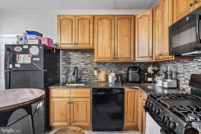 a kitchen with stainless steel appliances granite countertop a stove top oven a sink and cabinets