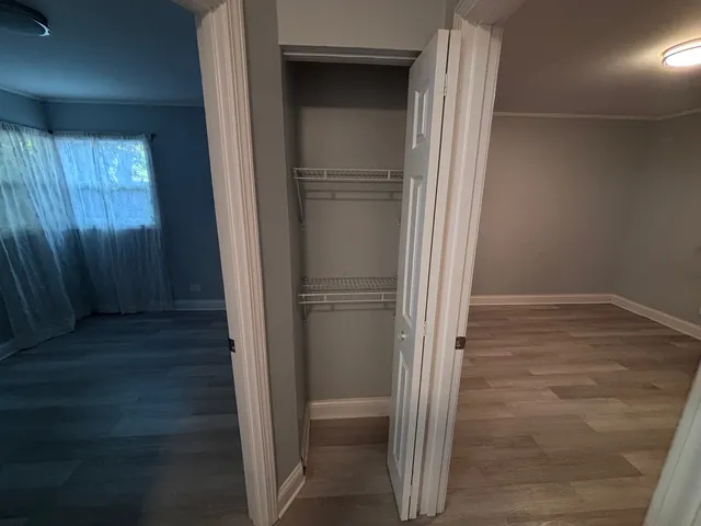 a view of an empty room with wooden floor