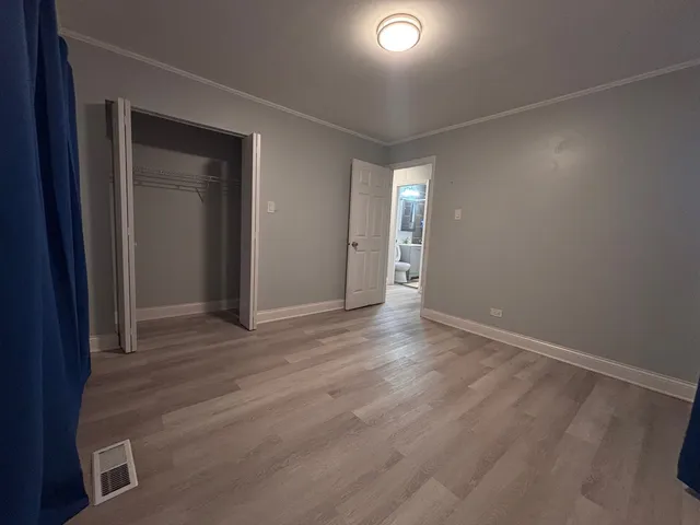 an empty room with wooden floor and closet