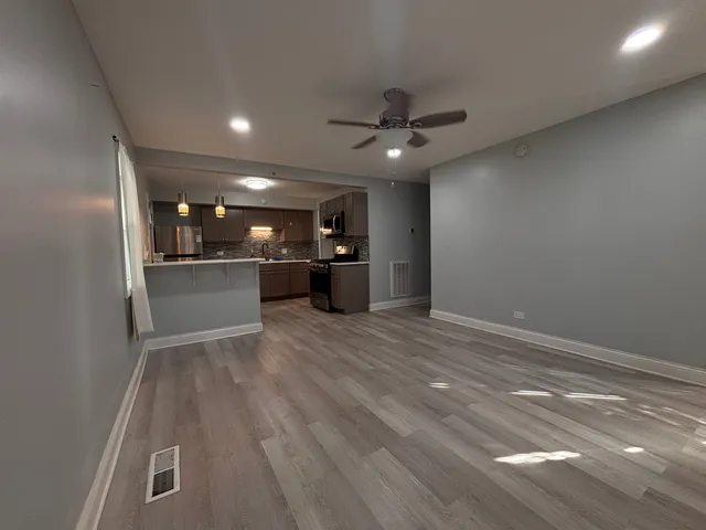 wooden floor in an empty room with a kitchen