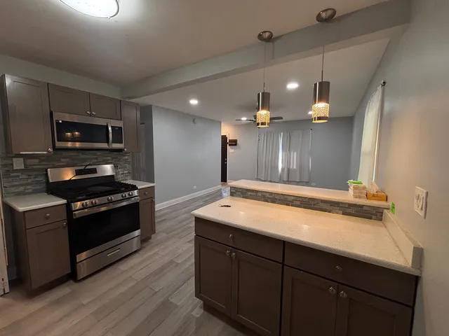a kitchen with kitchen island a counter space a sink and stainless steel appliances