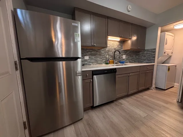 a kitchen with stainless steel appliances granite countertop a refrigerator and a sink
