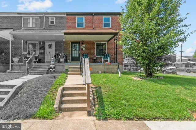 a front view of a house with a yard garden and outdoor seating
