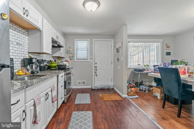 a kitchen with stainless steel appliances granite countertop a stove top oven a sink dishwasher and cabinets with wooden floor