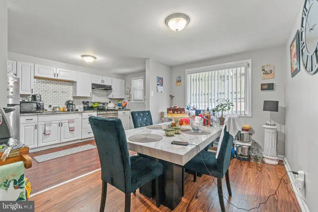 a kitchen with a dining table chairs and white cabinets