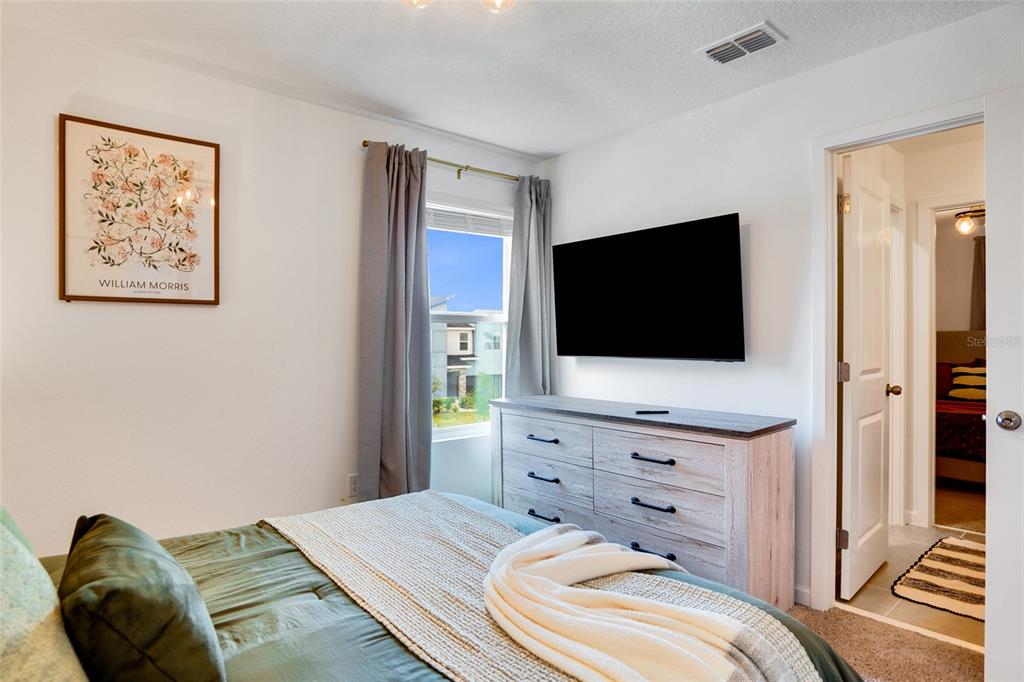 2341 Salty Winds Way Kissimmee, FL 34747 - Photo 48 of 79 a bedroom with a bed and a flat screen tv