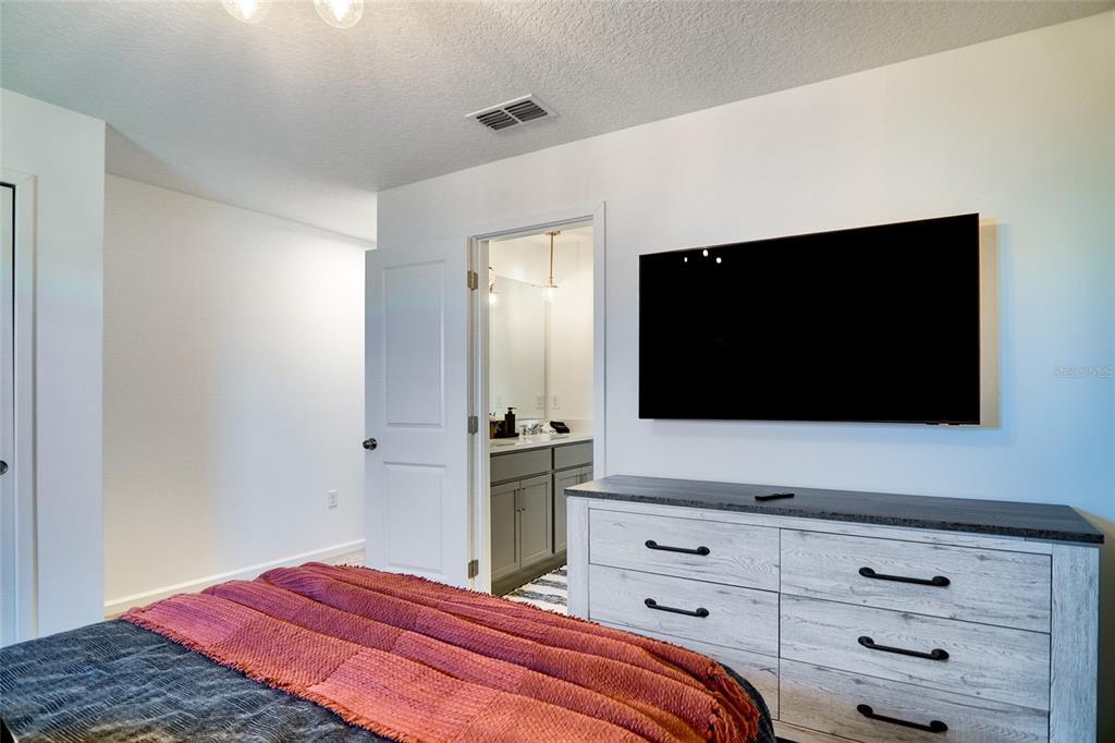 2341 Salty Winds Way Kissimmee, FL 34747 - Photo 52 of 79 a bedroom with a bed and a flat screen tv
