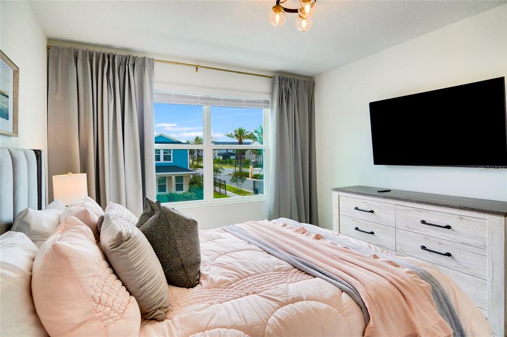 2341 Salty Winds Way Kissimmee, FL 34747 - Photo 55 of 79 a bedroom with a bed and a flat screen tv