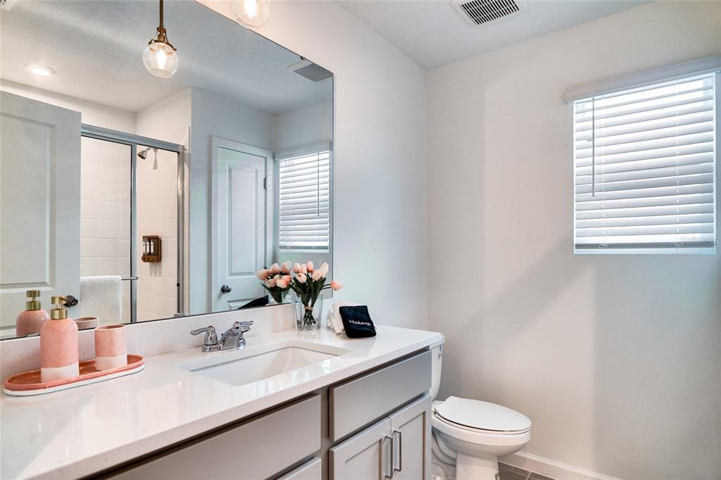 2341 Salty Winds Way Kissimmee, FL 34747 - Photo 56 of 79 a bathroom with a sink a toilet a mirror and vanity