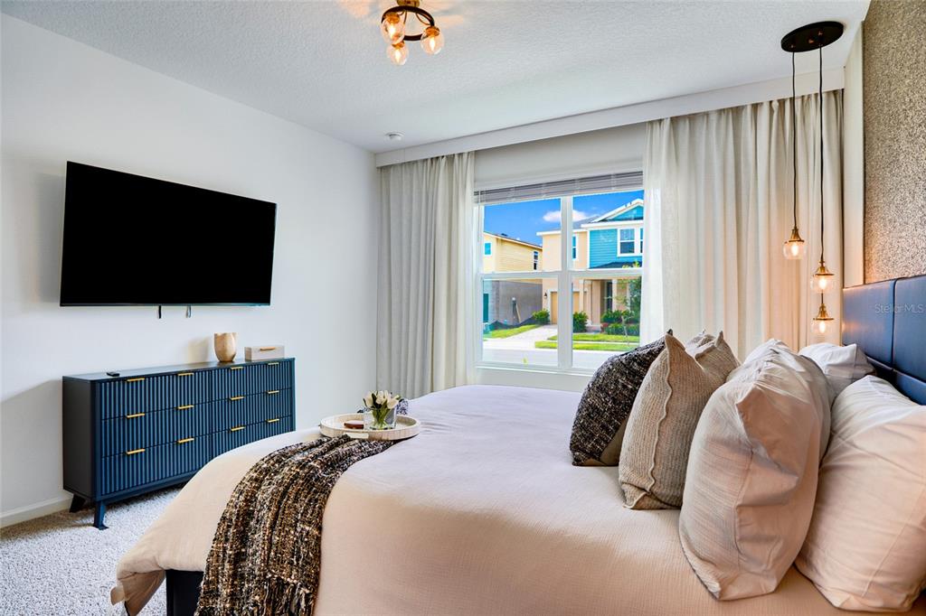 2341 Salty Winds Way Kissimmee, FL 34747 - Photo 6 of 79 a bedroom with a bed and a flat tv screen on dresser