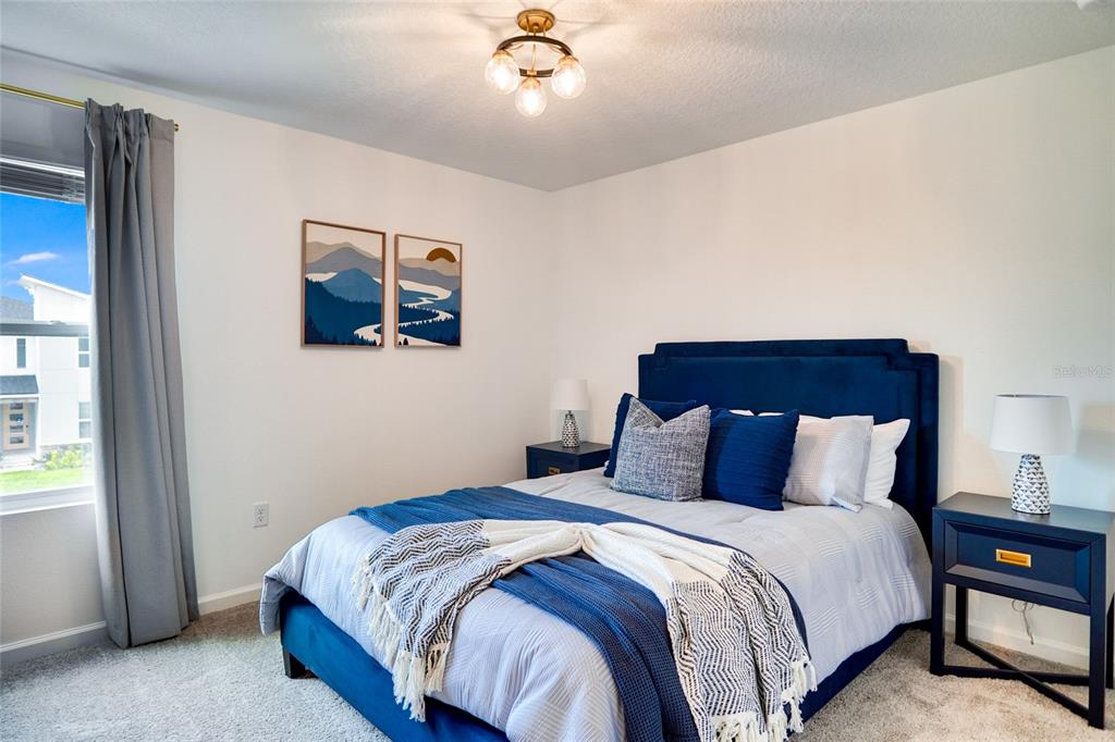 2341 Salty Winds Way Kissimmee, FL 34747 - Photo 62 of 79 a bedroom with a bed and a chandelier