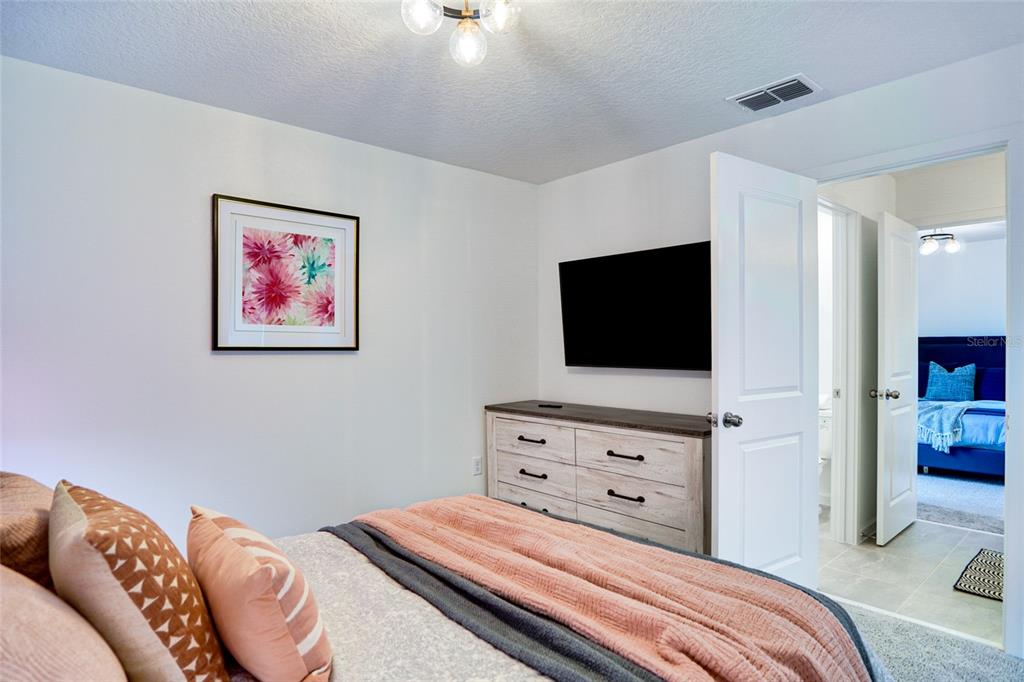 2341 Salty Winds Way Kissimmee, FL 34747 - Photo 64 of 79 a bedroom with a bed and a flat screen tv