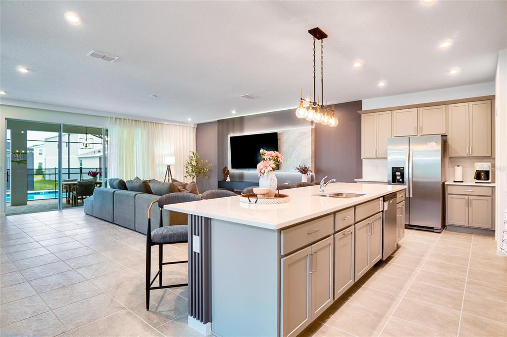 2341 Salty Winds Way Kissimmee, FL 34747 - Photo 8 of 79 a large kitchen with kitchen island a large counter top space a sink appliances and a view of living room