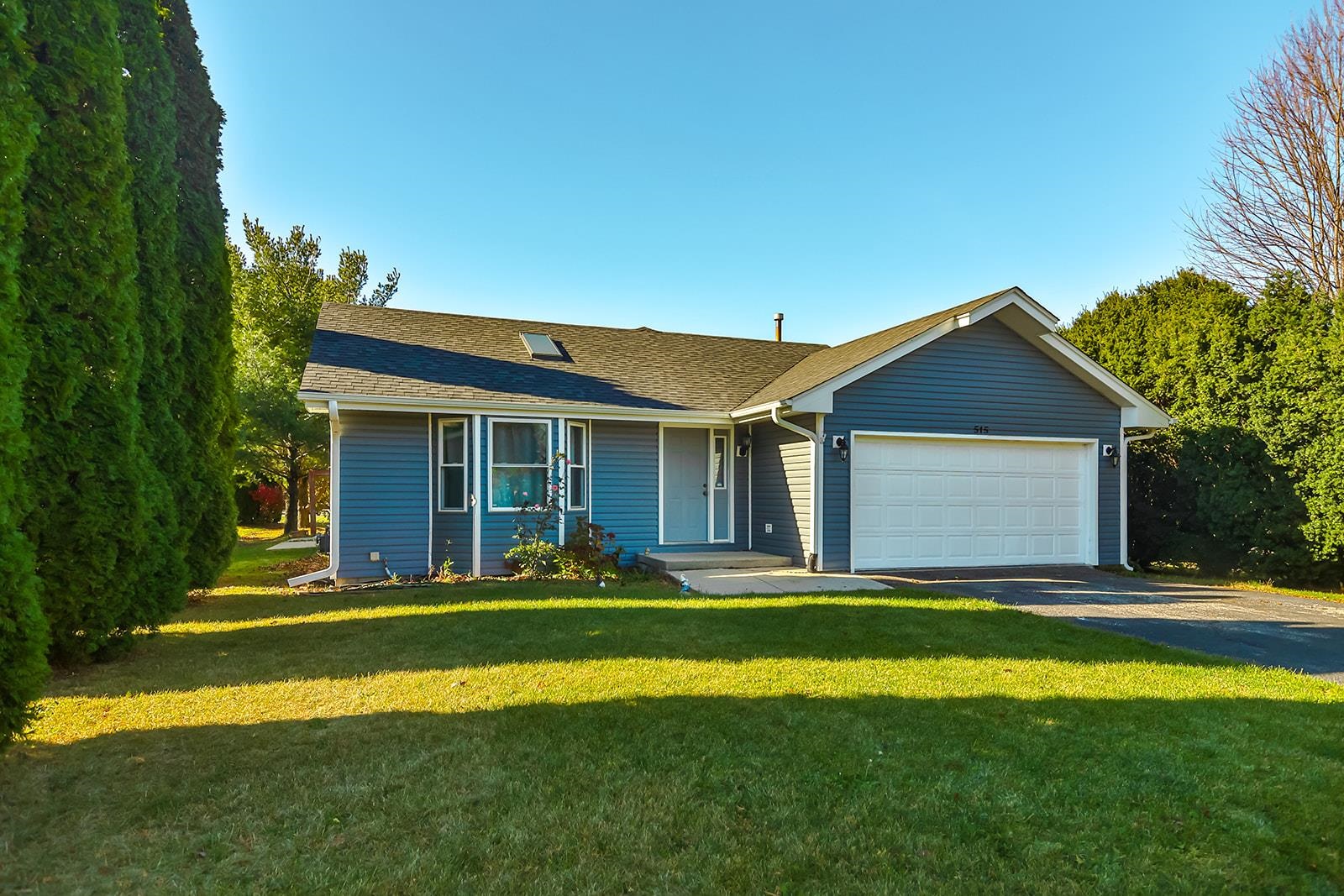 515 Pembroke Road Southwest Poplar Grove, IL 61065 - Photo 1 of 24 a front view of a house with a yard and trees