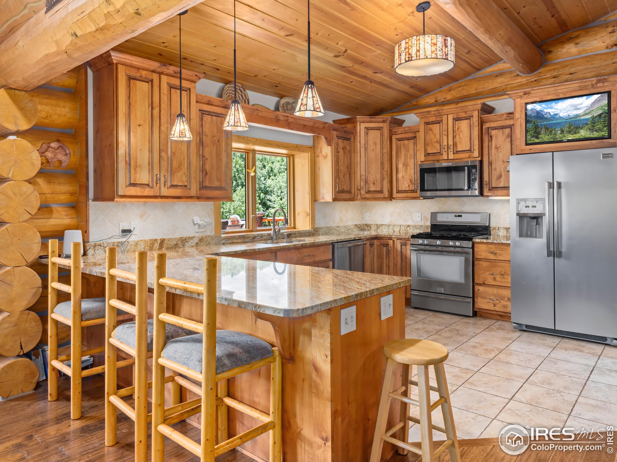 470 Big John Road Lyons, CO 80540 - Photo 12 of 38 a kitchen with stainless steel appliances kitchen island granite countertop a refrigerator and a stove top oven