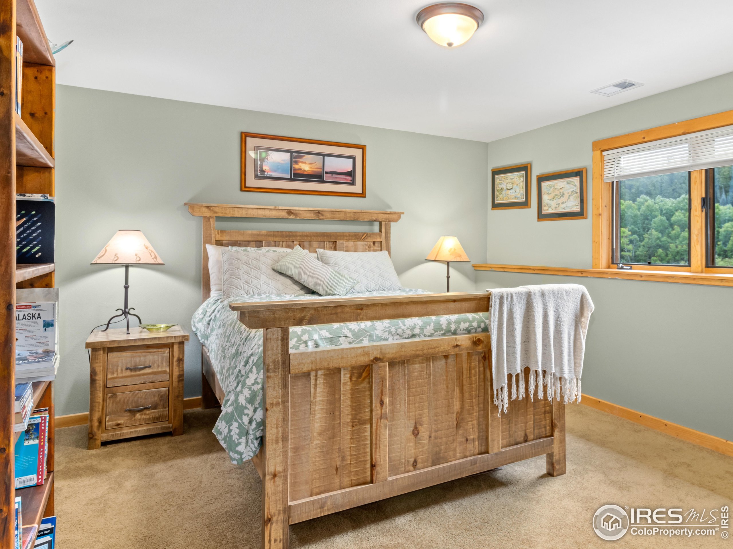 470 Big John Road Lyons, CO 80540 - Photo 22 of 38 a bedroom with a bed and a lamp next to a window