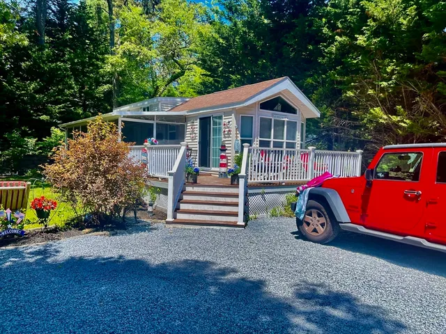 a front view of house with deck and yard