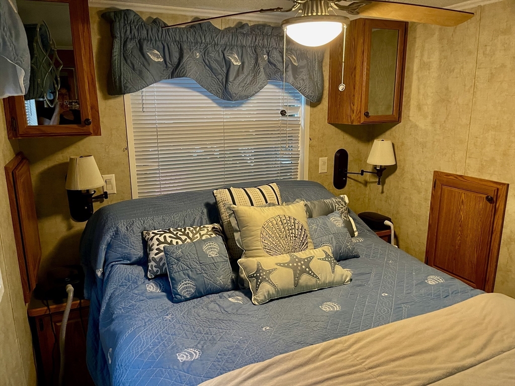 185 Cotuit Road, Unit C5 ASPEN Sandwich, MA 02563 - Photo 13 of 17 a bedroom with a bed lamp and a mirror on the dresser