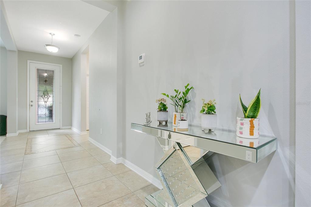 4918 Wildwood Pointe Road Winter Garden, FL 34787 - Photo 2 of 33 a living room with a potted plant on a counter and a potted plant