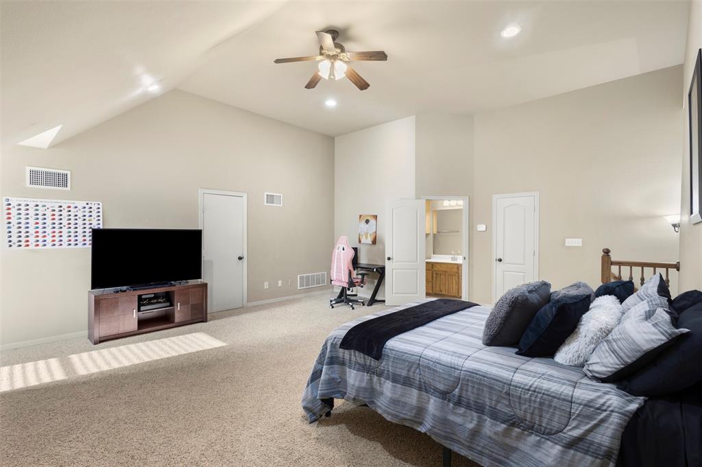 105 Country Ridge Court Red Oak, TX 75154 - Photo 30 of 40 a bedroom with a bed and a flat tv screen on wall