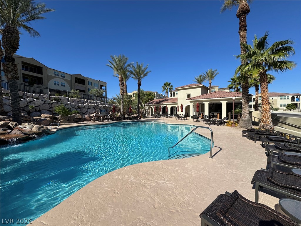 2555 Hampton Road, Unit 4205 Henderson, NV 89052 - Photo 52 of 52 Lush landscaping surrounds this inviting pool, offering a refreshing oasis for relaxation.