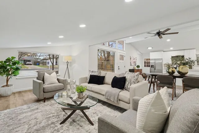 a living room with stainless steel appliances kitchen island furniture and a window