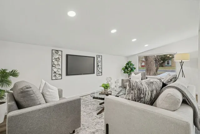 a living room with furniture kitchen view and a couch