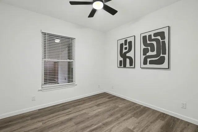 a view of an empty room with wooden floor