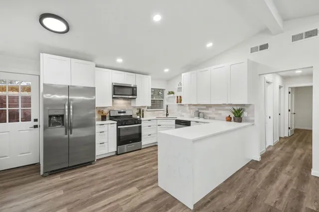 a large kitchen with cabinets and stainless steel appliances