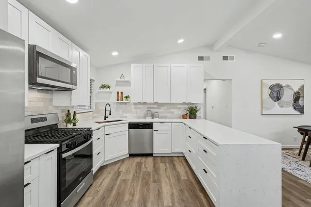 a kitchen with granite countertop white cabinets and white appliances