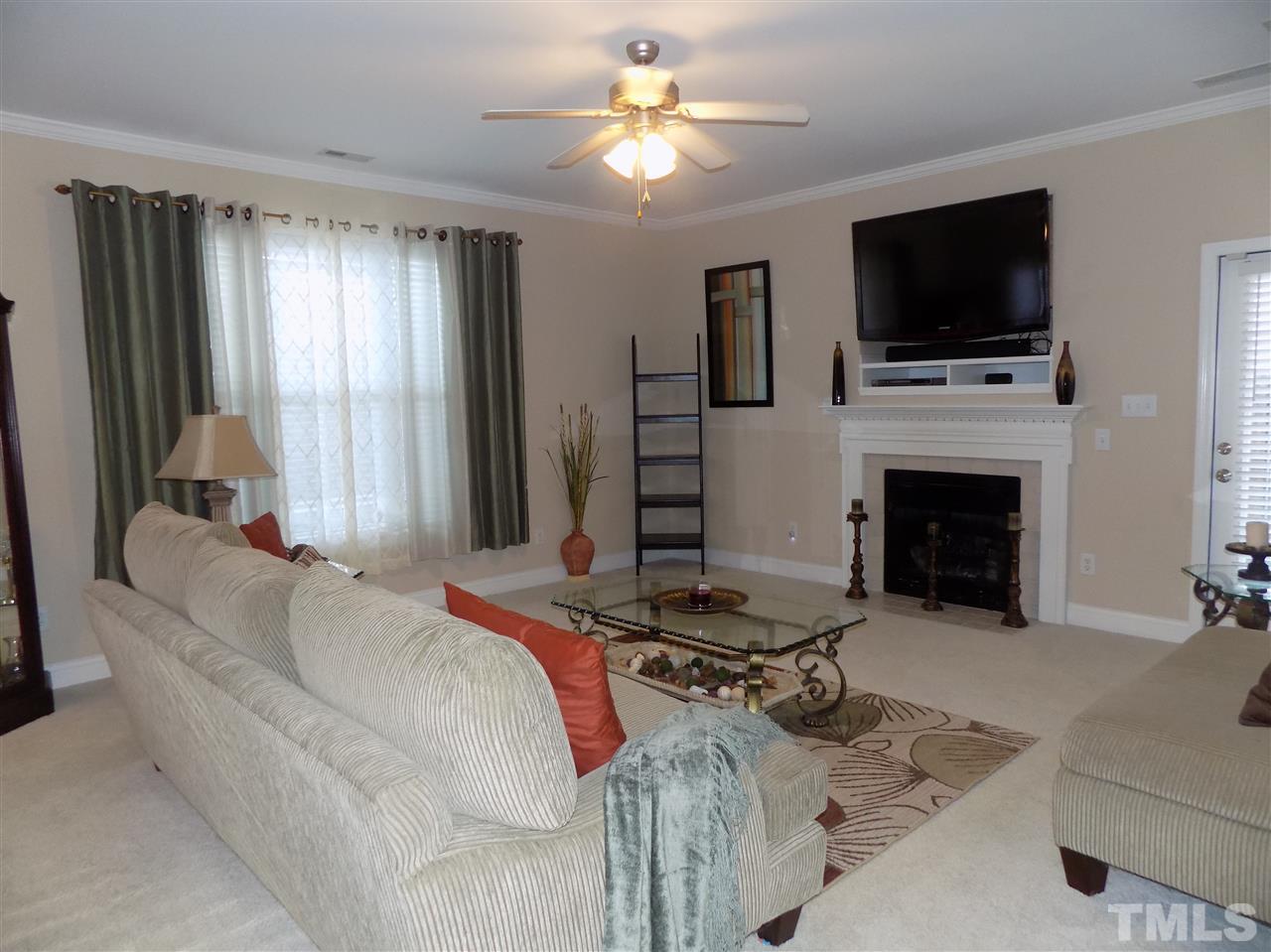 3914 Magnolia Pond Road Raleigh, NC 27610 - Photo 7 of 15 a living room with furniture a fireplace and a flat screen tv